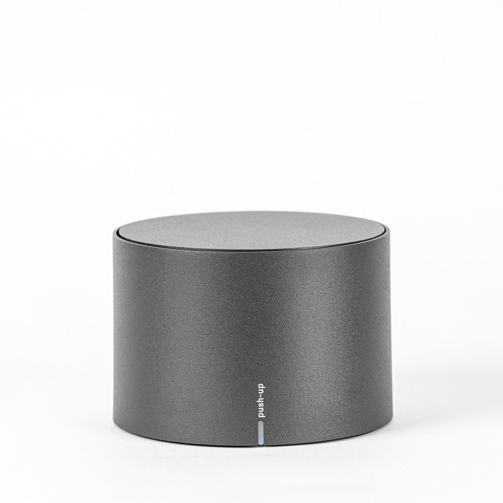 Grey cylindrical container with matte surface and "push-up" text on the front.