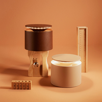 Two modern cylindrical lamps, one brown with wood base and one beige, with internal light, next to two wooden rulers on background