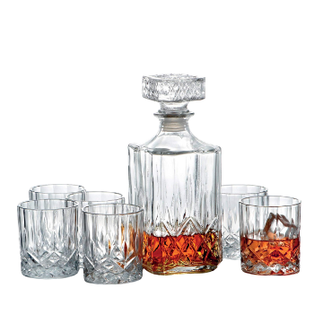 Set di caraffa e sei bicchieri in vetro trasparente con dettagli cesellati, contenenti liquido ambrato.