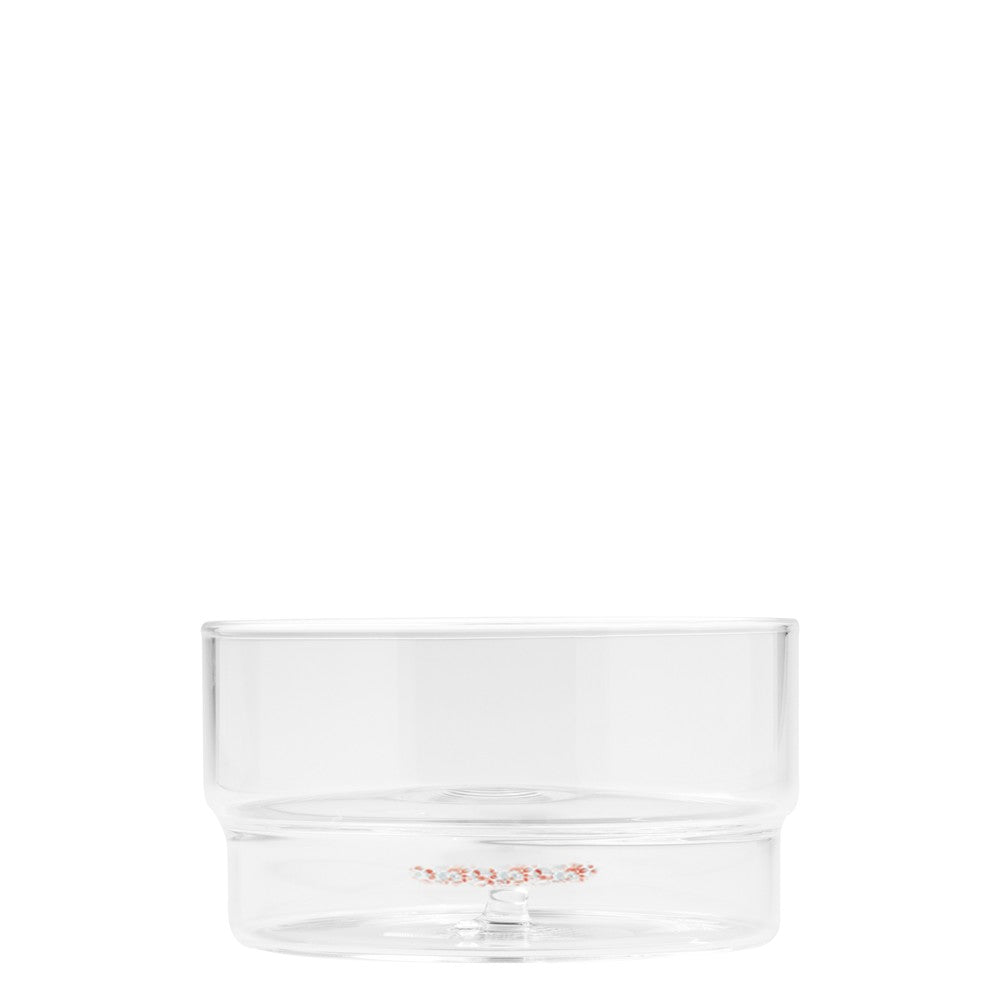 Transparent cylindrical tumbler with solid base; internal decoration on the bottom. White background.