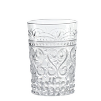Transparent glass tumbler with raised floral and dot decorations, bubble base, white background.
