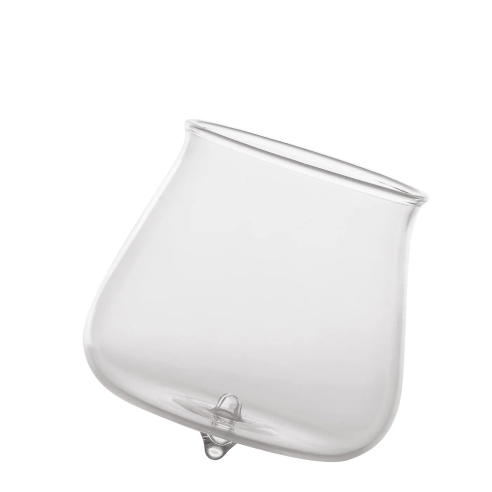 Transparent glass tumbler with rounded base and slightly raised rim on white background