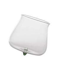 Transparent glass tumbler with green triangular base, rounded shape and slightly flared rim, white background